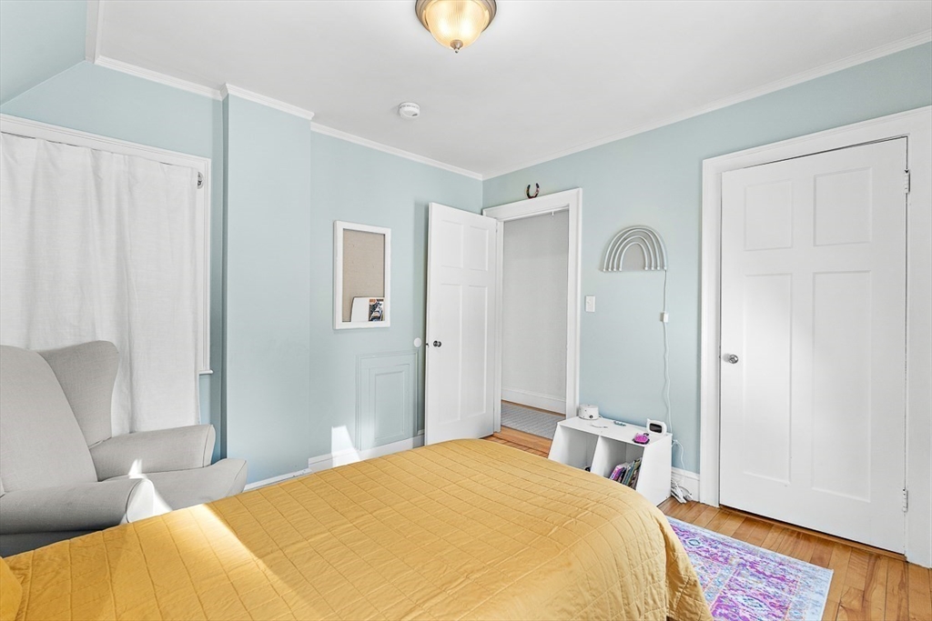 23 Jefferson Road Winchester, MA 01890 - Photo 33 of 41 a bedroom with a bed and a chandelier
