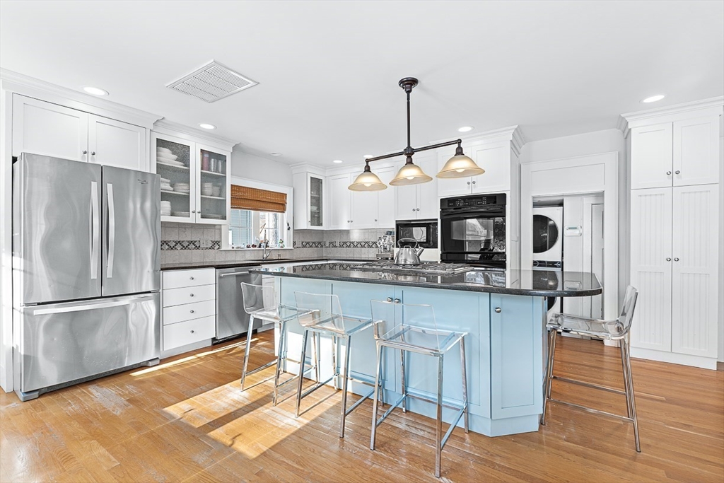 23 Jefferson Road Winchester, MA 01890 - Photo 9 of 41 a kitchen with stainless steel appliances granite countertop a refrigerator a sink dishwasher a stove and white cabinets with wooden floor
