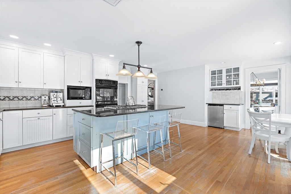 23 Jefferson Road Winchester, MA 01890 - Photo 10 of 41 a kitchen with stainless steel appliances granite countertop a stove top oven a sink dishwasher and a refrigerator with wooden floor