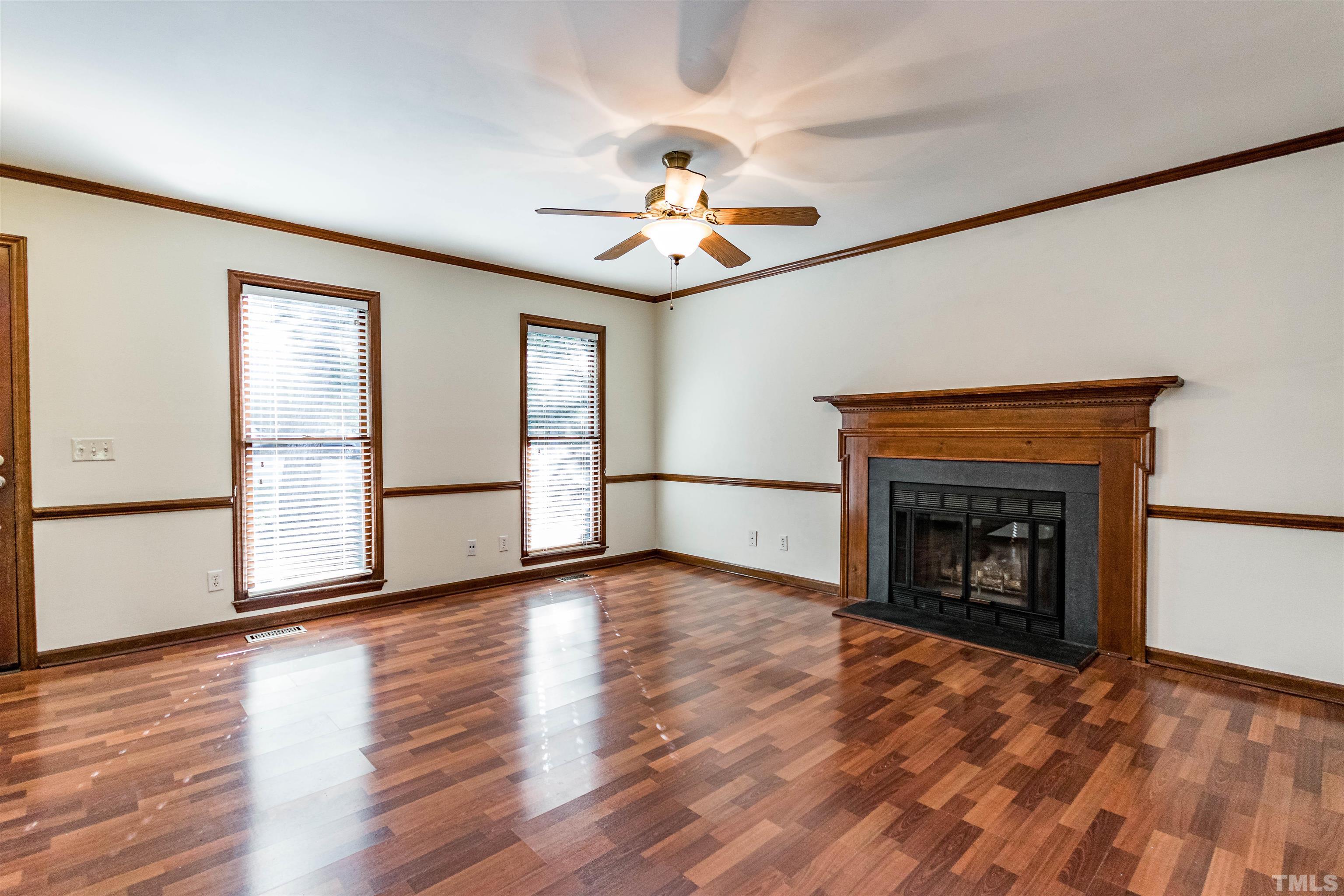 5218 Deer Haven Drive, Unit 5218 Raleigh, NC 27606 - Photo 11 of 27 an empty room with wooden floor fireplace and windows