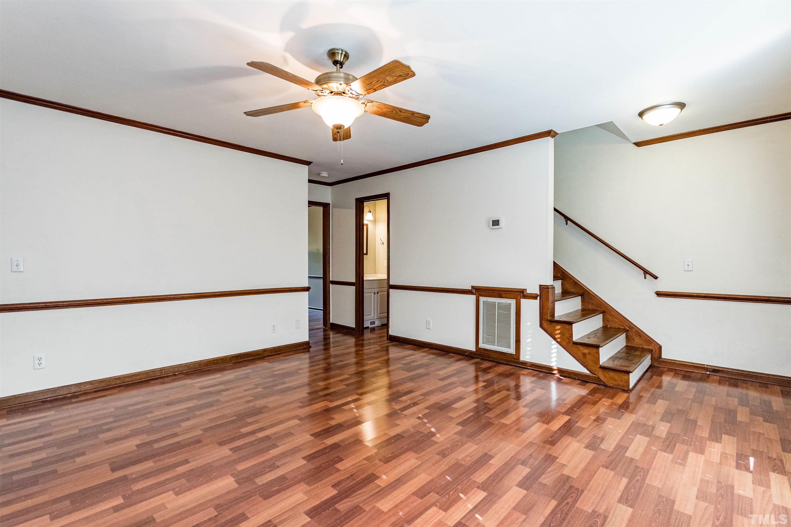 5218 Deer Haven Drive, Unit 5218 Raleigh, NC 27606 - Photo 13 of 27 a view of an empty room with wooden floor and a ceiling fan
