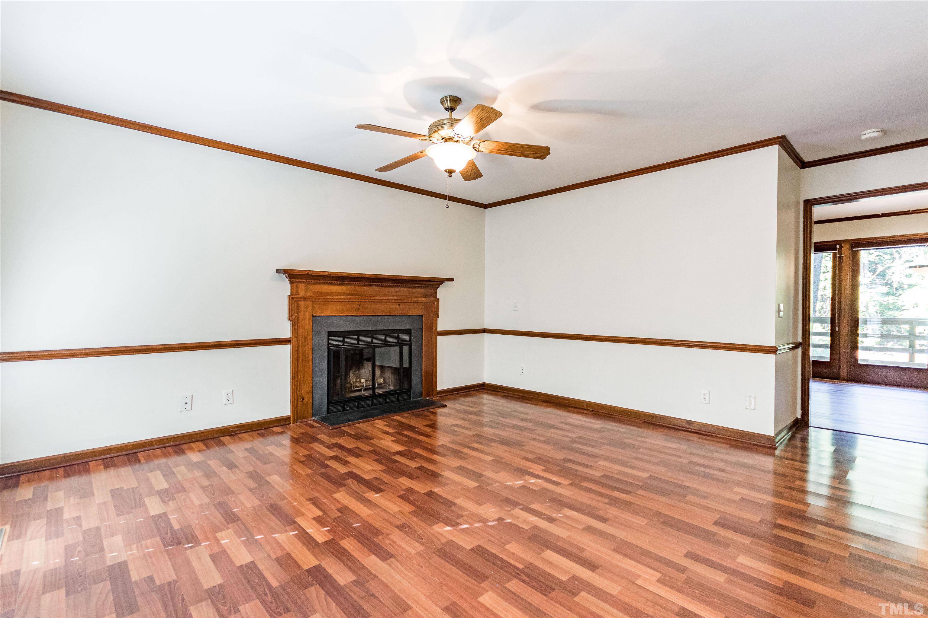 5218 Deer Haven Drive, Unit 5218 Raleigh, NC 27606 - Photo 14 of 27 a view of an empty room with wooden floor fireplace and a window