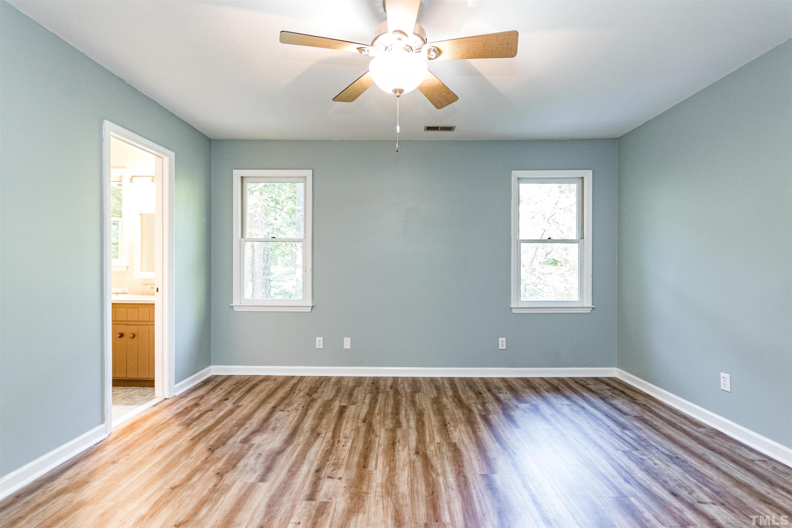 5218 Deer Haven Drive, Unit 5218 Raleigh, NC 27606 - Photo 18 of 27 a view of room with window ceiling fan and wooden floor