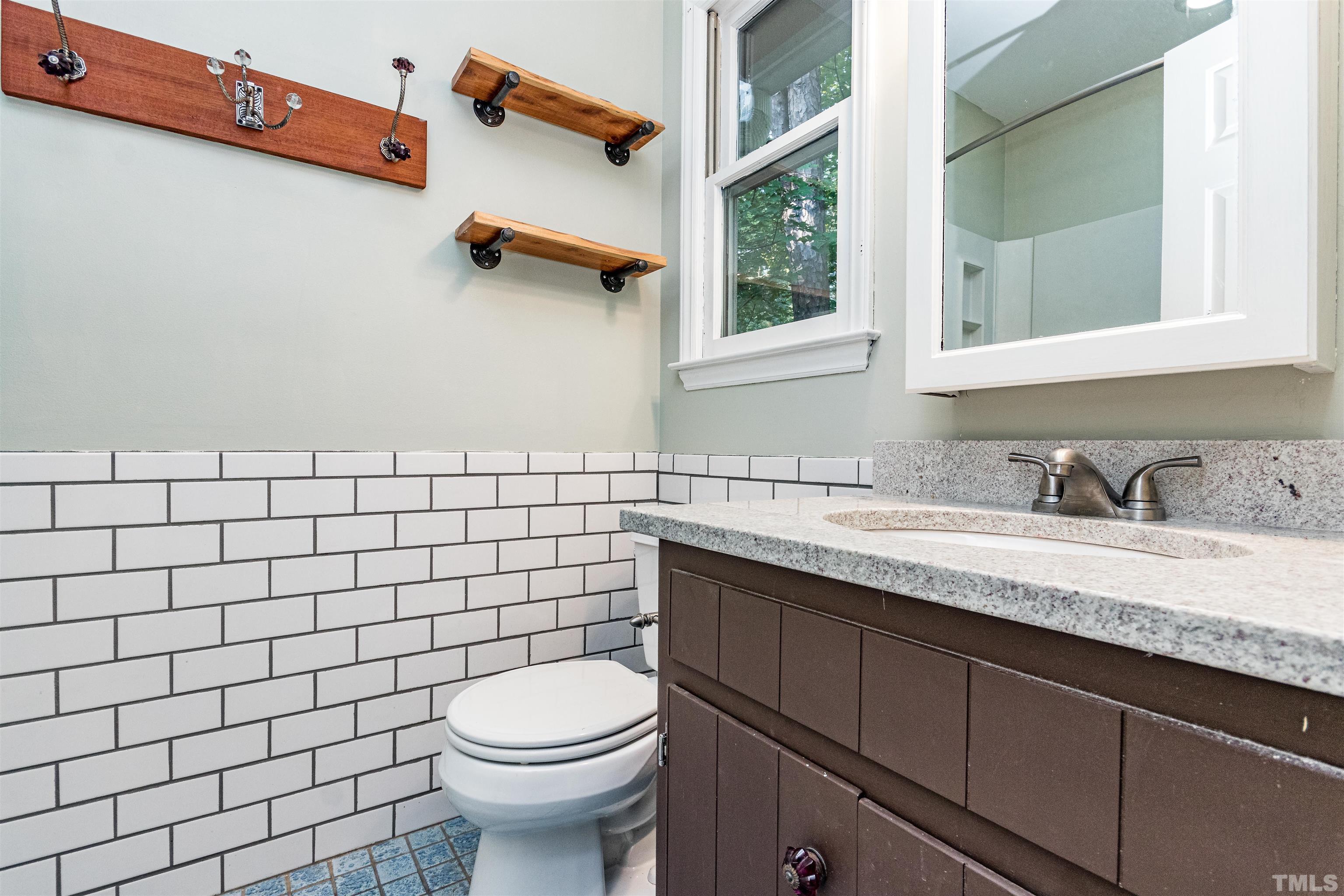 5218 Deer Haven Drive, Unit 5218 Raleigh, NC 27606 - Photo 21 of 27 a bathroom with a granite countertop toilet sink and mirror