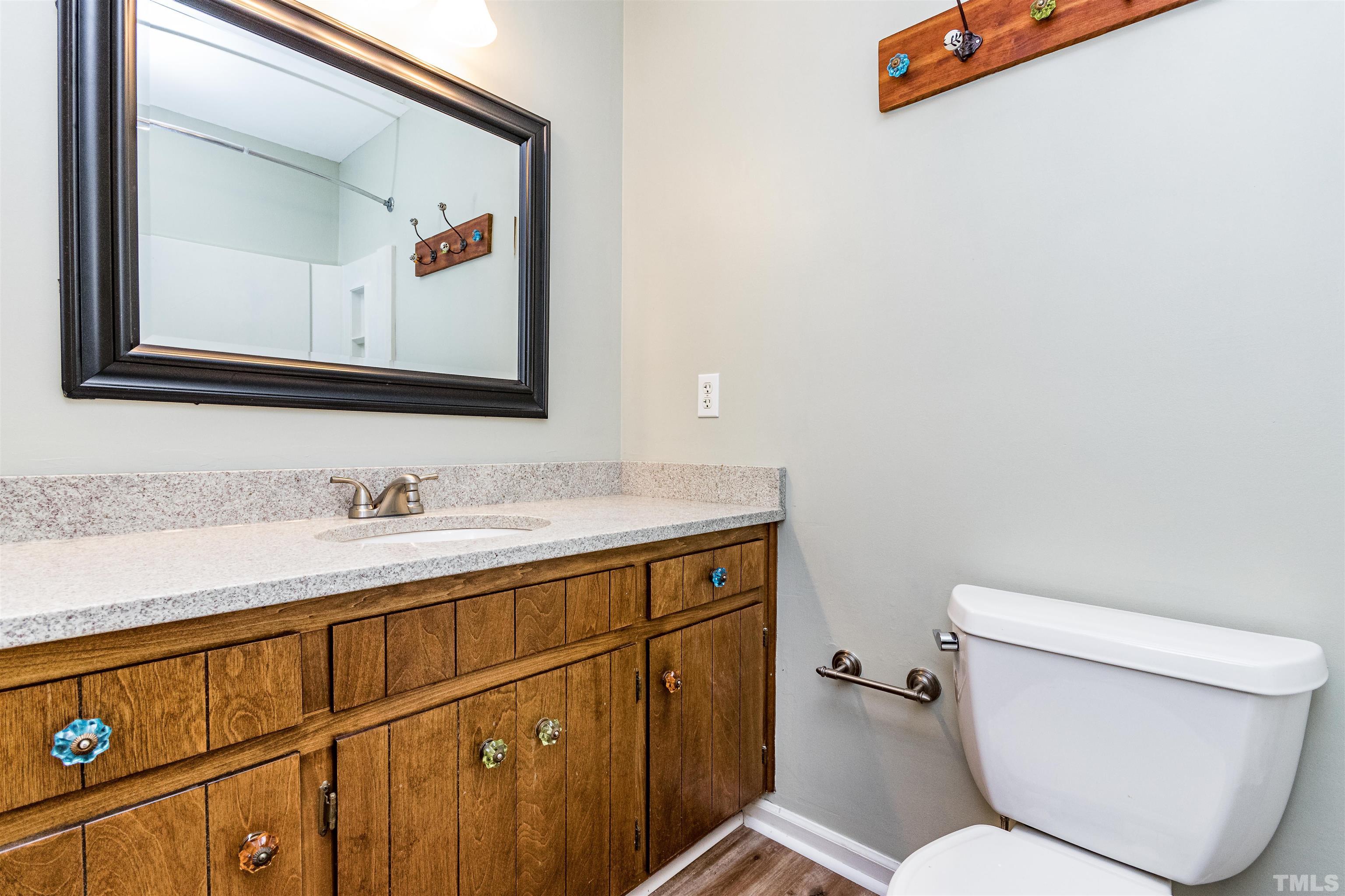 5218 Deer Haven Drive, Unit 5218 Raleigh, NC 27606 - Photo 24 of 27 a bathroom with a toilet a sink and mirror