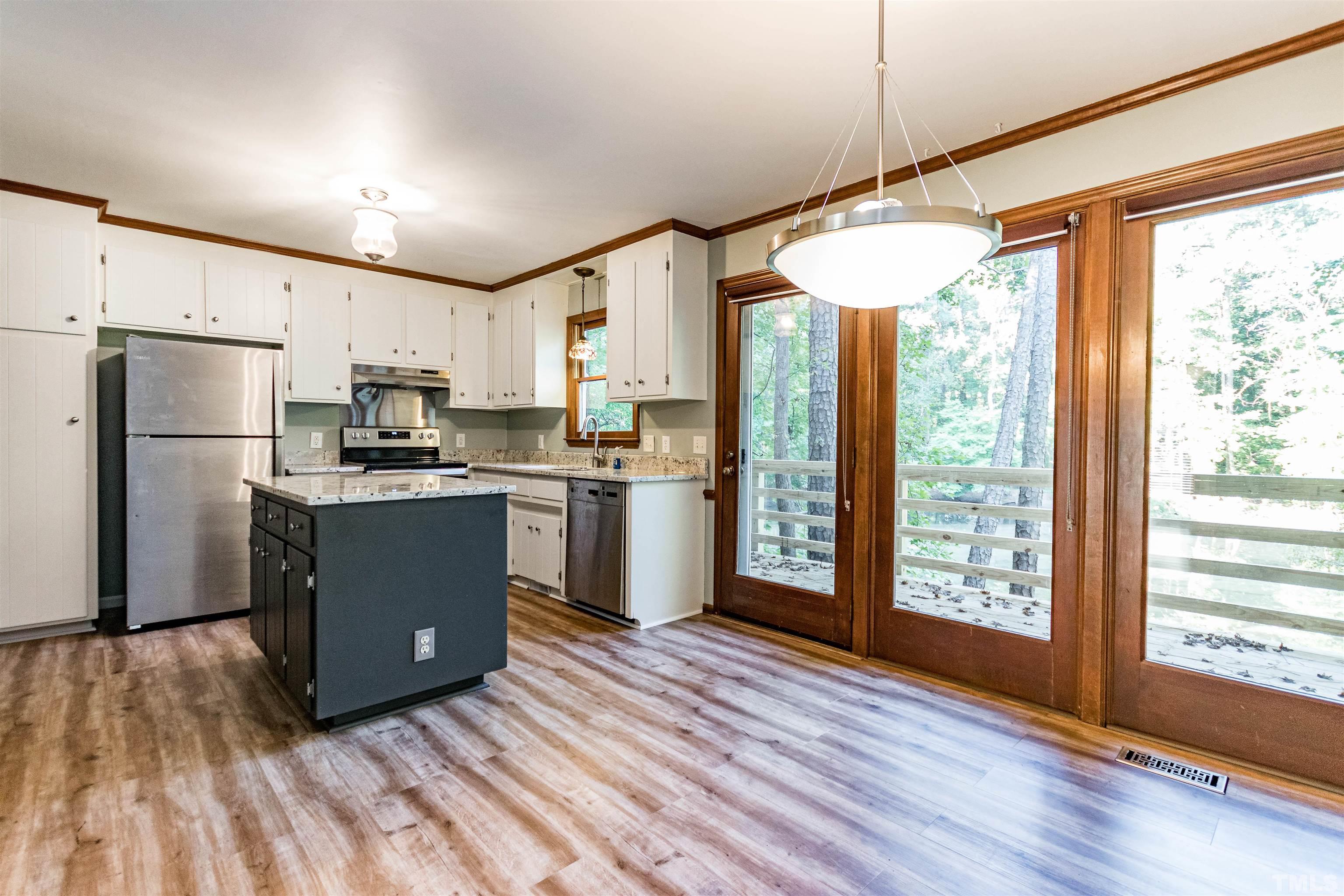 5218 Deer Haven Drive, Unit 5218 Raleigh, NC 27606 - Photo 4 of 27 a kitchen with stainless steel appliances granite countertop a refrigerator a sink dishwasher a stove and white countertops with wooden floor
