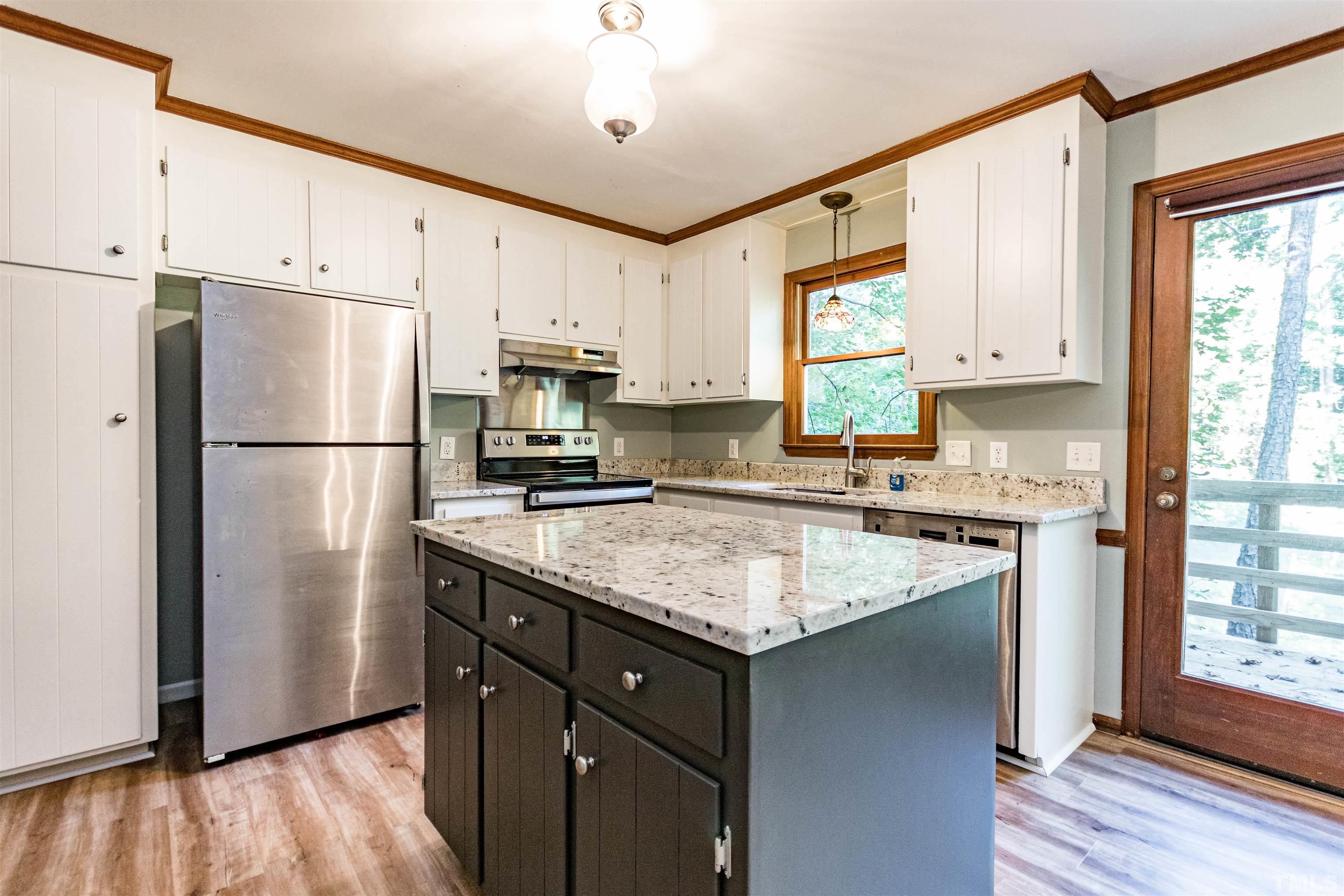 5218 Deer Haven Drive, Unit 5218 Raleigh, NC 27606 - Photo 5 of 27 a kitchen with stainless steel appliances granite countertop a refrigerator a sink dishwasher a stove and white cabinets with wooden floor