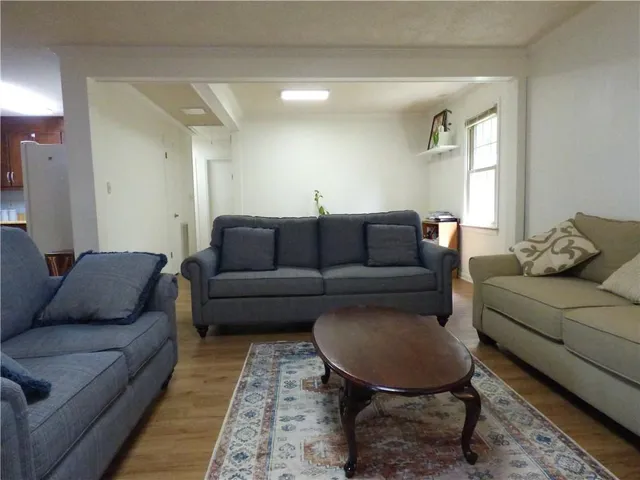 a living room with furniture a rug and a window
