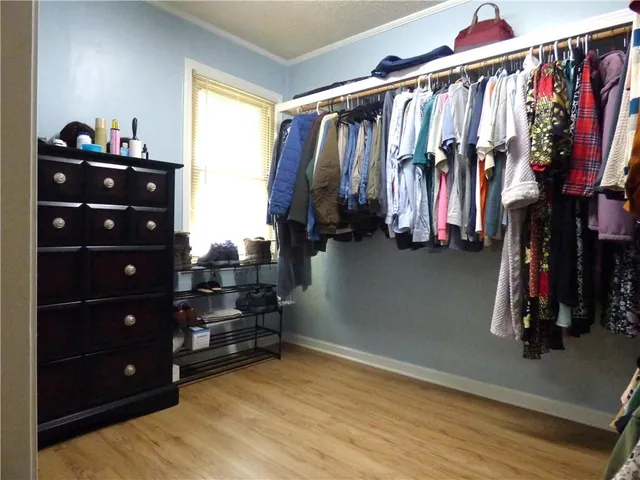 a view of walk in closet with clothes and shoes