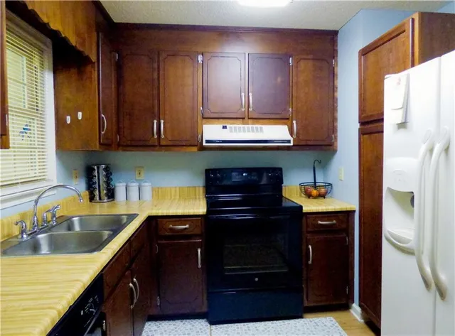 a kitchen with granite countertop stainless steel appliances and wooden cabinets