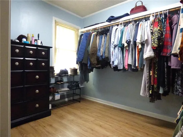 a view of walk in closet with clothes and shoes