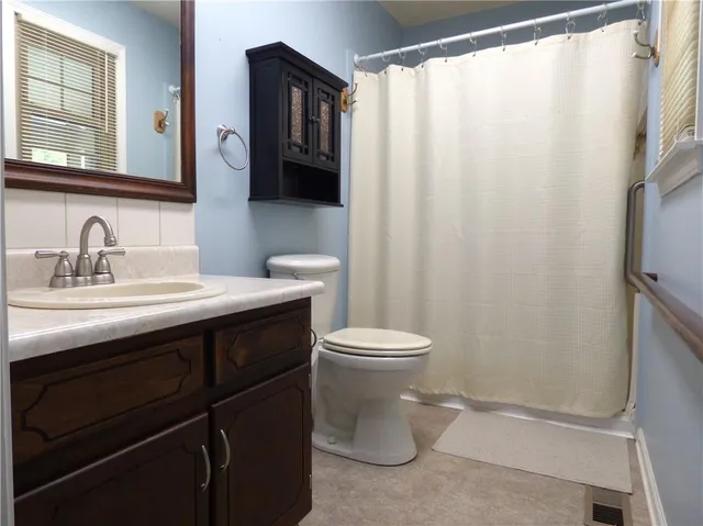a bathroom with a sink a toilet and a mirror