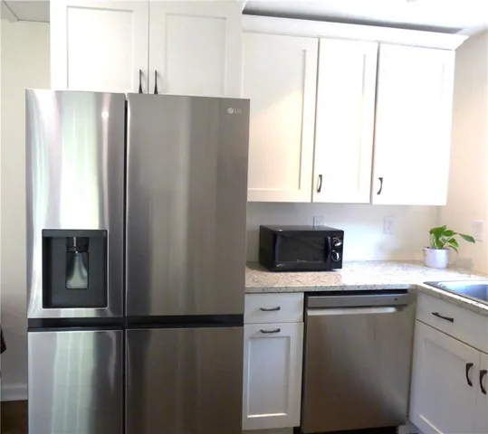 a kitchen with metallic refrigerator and window