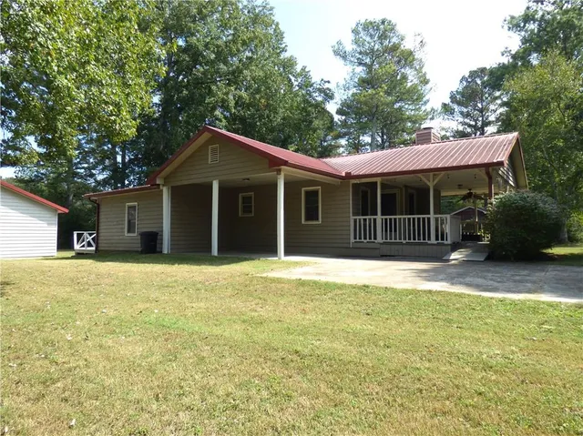 a front view of a house with a garden and trees