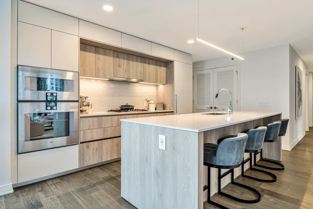 a kitchen with kitchen island a stove a table and chairs in it