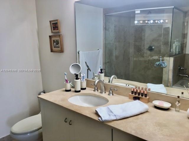 3232 Southwest 22nd Terrace, Unit 1303 Miami, FL 33145 - Photo 20 of 43 a bathroom with a granite countertop sink a toilet and a mirror