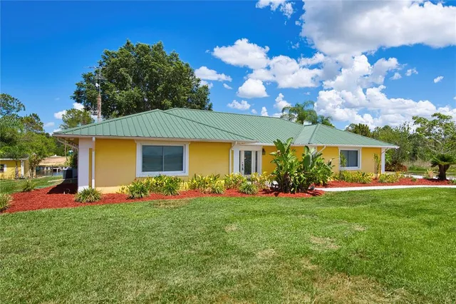 a front view of a house with a garden and trees