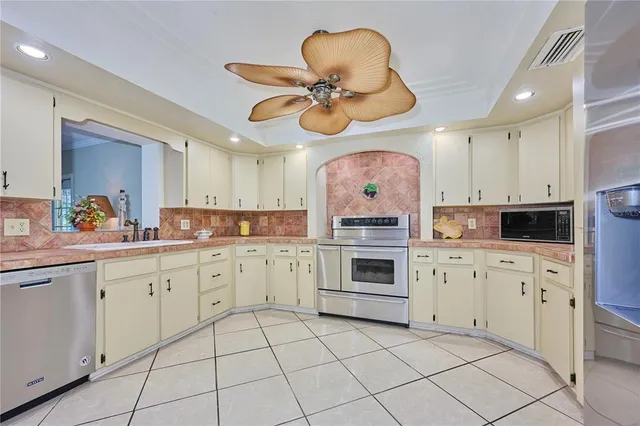 a kitchen with stainless steel appliances granite countertop a stove a sink and a microwave