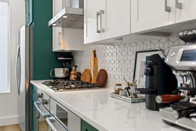 a kitchen with a sink a stove and cabinets