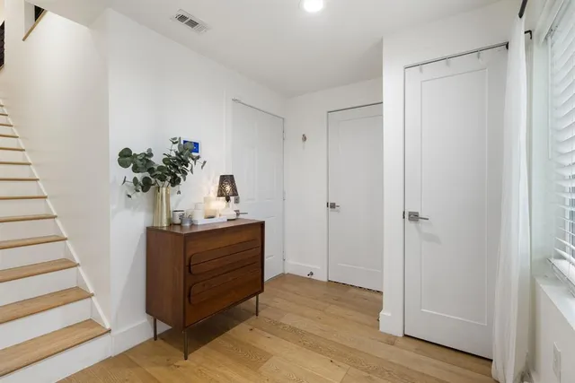 a room with wooden floor and potted plant