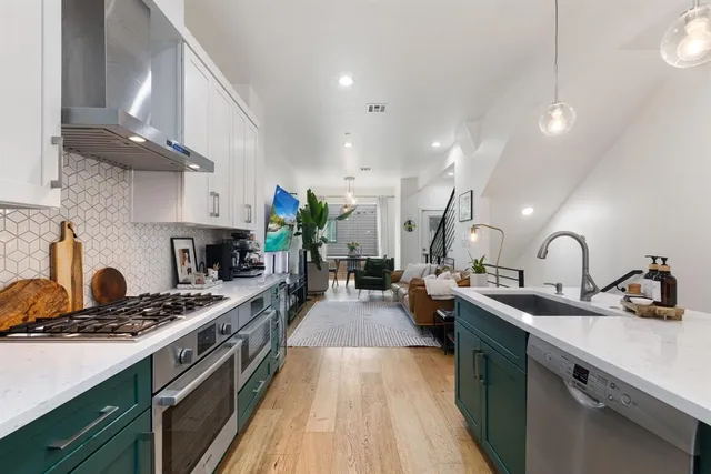 a kitchen with kitchen island a sink a stove and wooden floors