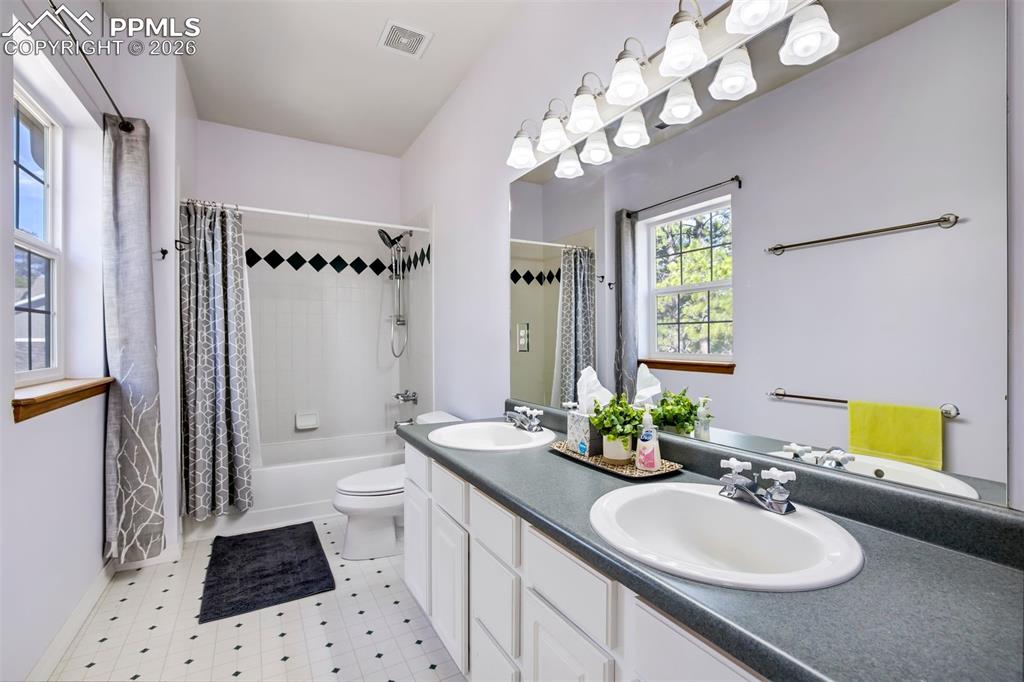 18554 Wetherill Road Monument, CO 80132 - Photo 35 of 50 a bathroom with a sink a toilet a mirror a vanity and window