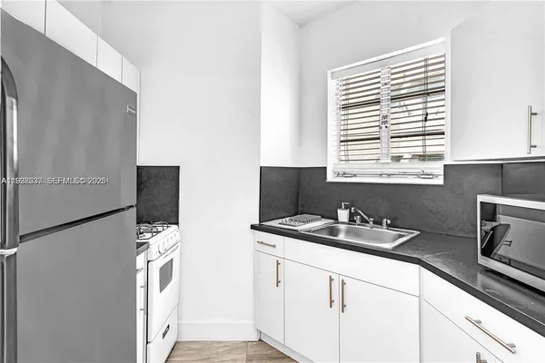 a kitchen with stainless steel appliances granite countertop a sink and a microwave