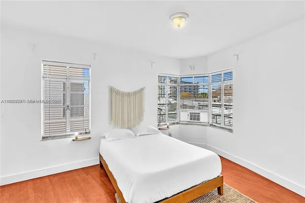 a large bed sitting in a bedroom next to a window