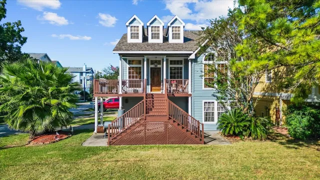 a front view of a house with a yard and potted plants