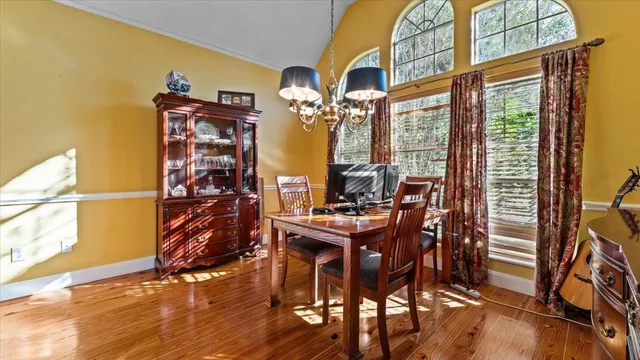 a view of a dining room with furniture a chandelier and wooden floor