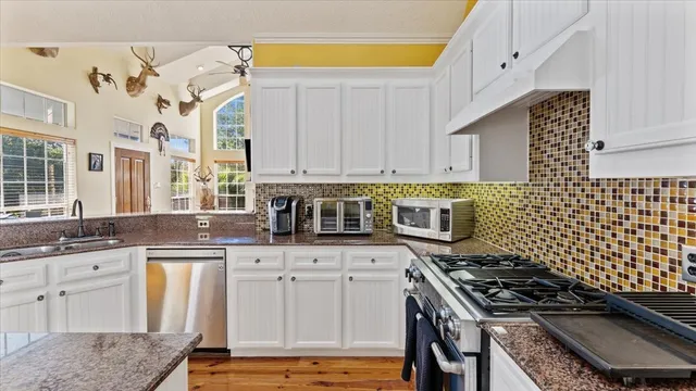 a kitchen with stainless steel appliances granite countertop a stove and a refrigerator