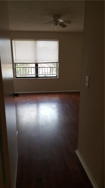 4541 West McNab Road, Unit 26 Pompano Beach, FL 33069 - Photo 3 of 12 an empty room with wooden floor and windows
