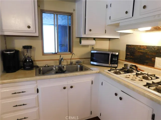 a kitchen with stainless steel appliances a stove a sink and a microwave