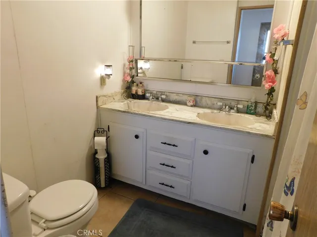 a bathroom with a granite countertop toilet sink and mirror