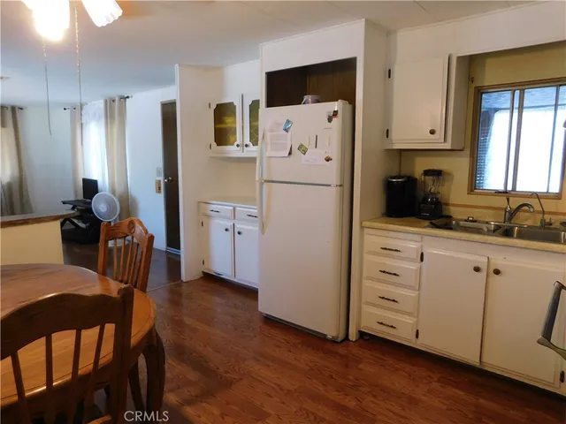 a kitchen with white cabinets and refrigerator