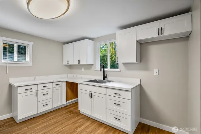 a kitchen with white cabinets stainless steel appliances and sink
