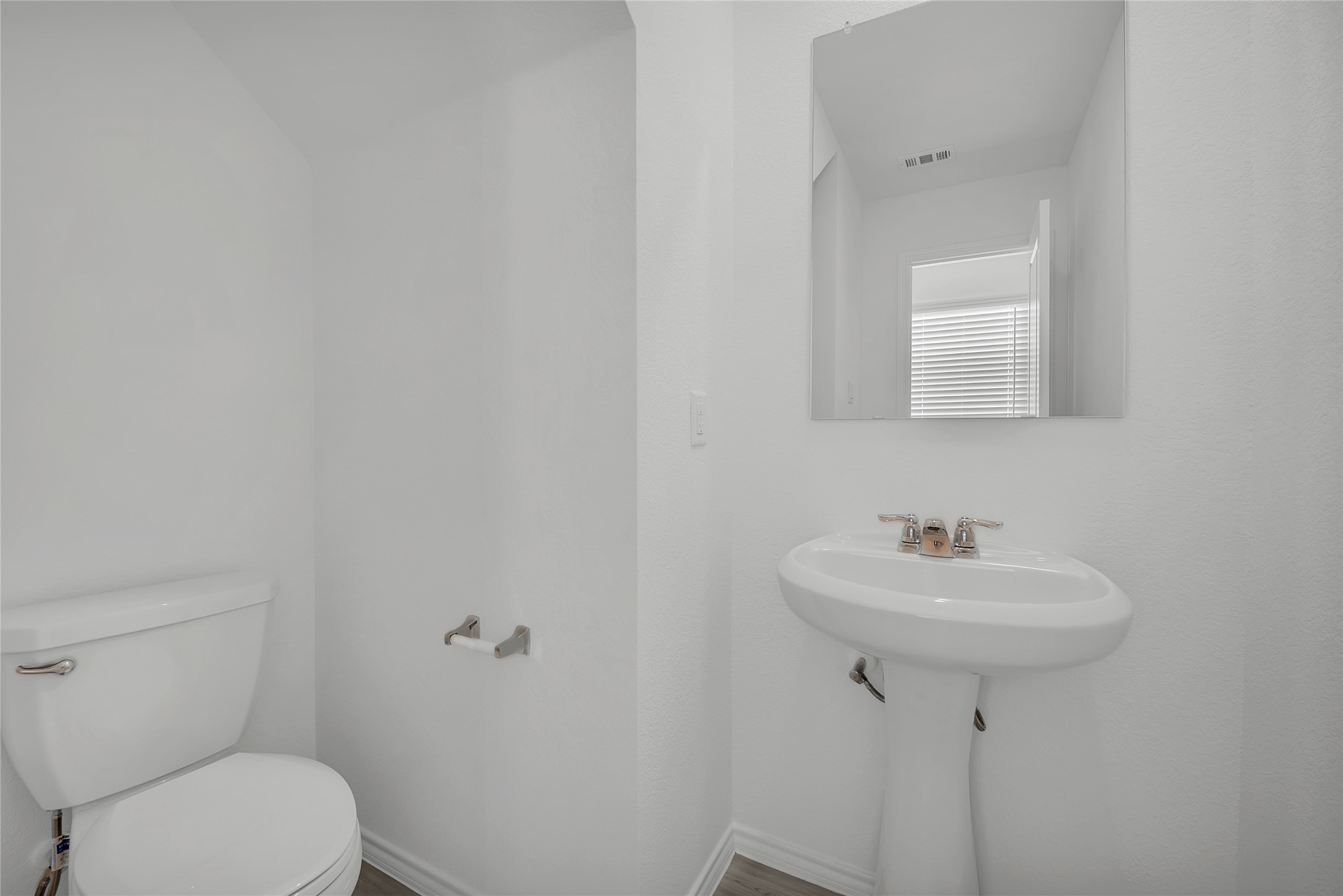 309 Marty Allen Loop Jarrell, TX 76537 - Photo 7 of 33 Powder room featuring a white pedestal sink, white toilet, and a rectangular wall-mounted mirror