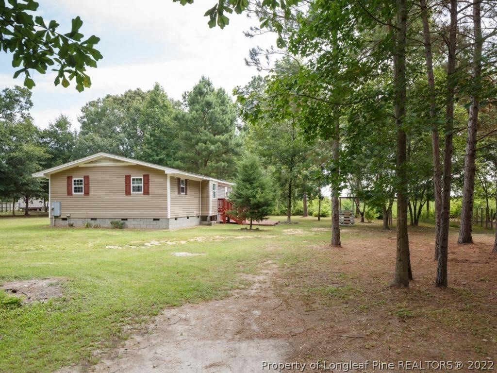 7661 Rufus Johnson Road, Unit 2 Fayetteville, NC 28306 - Photo 11 of 14 a front view of a house with a yard and trees
