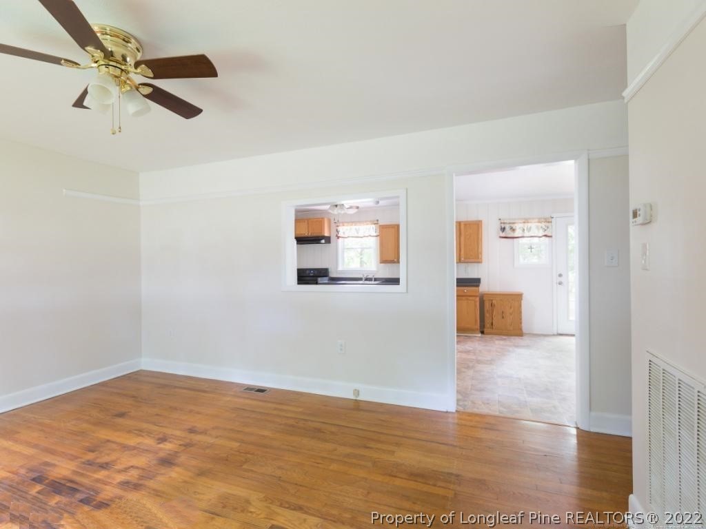 7661 Rufus Johnson Road, Unit 2 Fayetteville, NC 28306 - Photo 3 of 14 a view of a livingroom with wooden floor and a ceiling fan