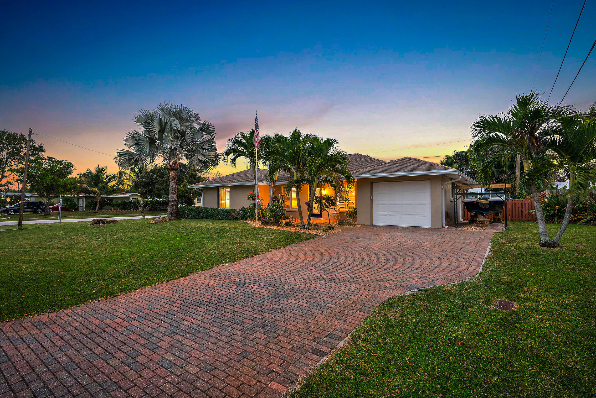 100 Windsor Road West Jupiter, FL 33469 - Photo 11 of 11 a front view of a house with a yard and a garage