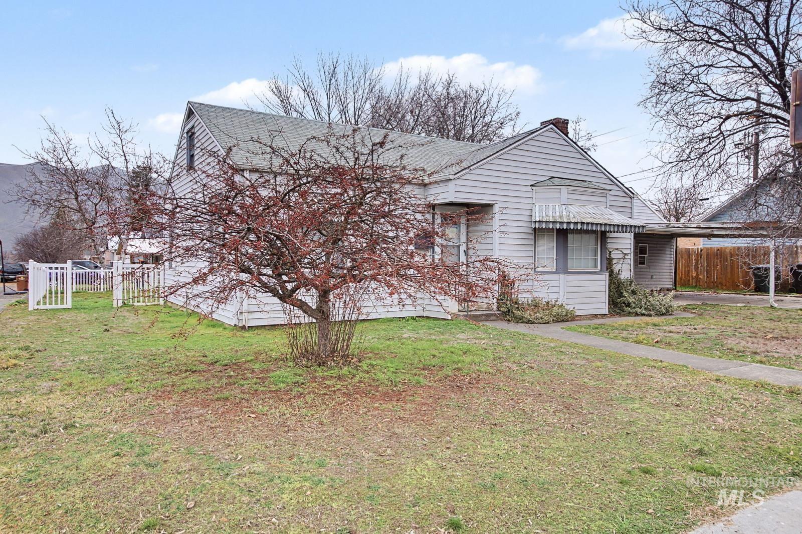 View of front facade featuring an attached carport and a chimney