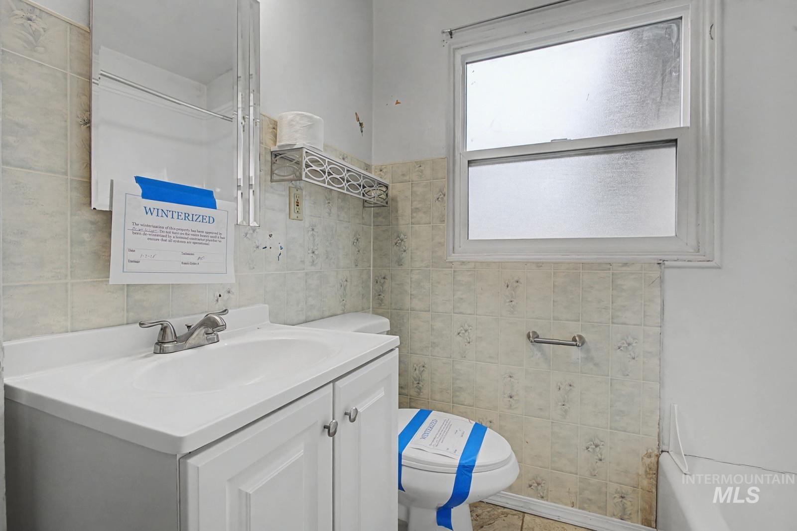 918 Elm Street Clarkston, WA 99403 - Photo 11 of 35 Full bathroom with vanity and tile walls