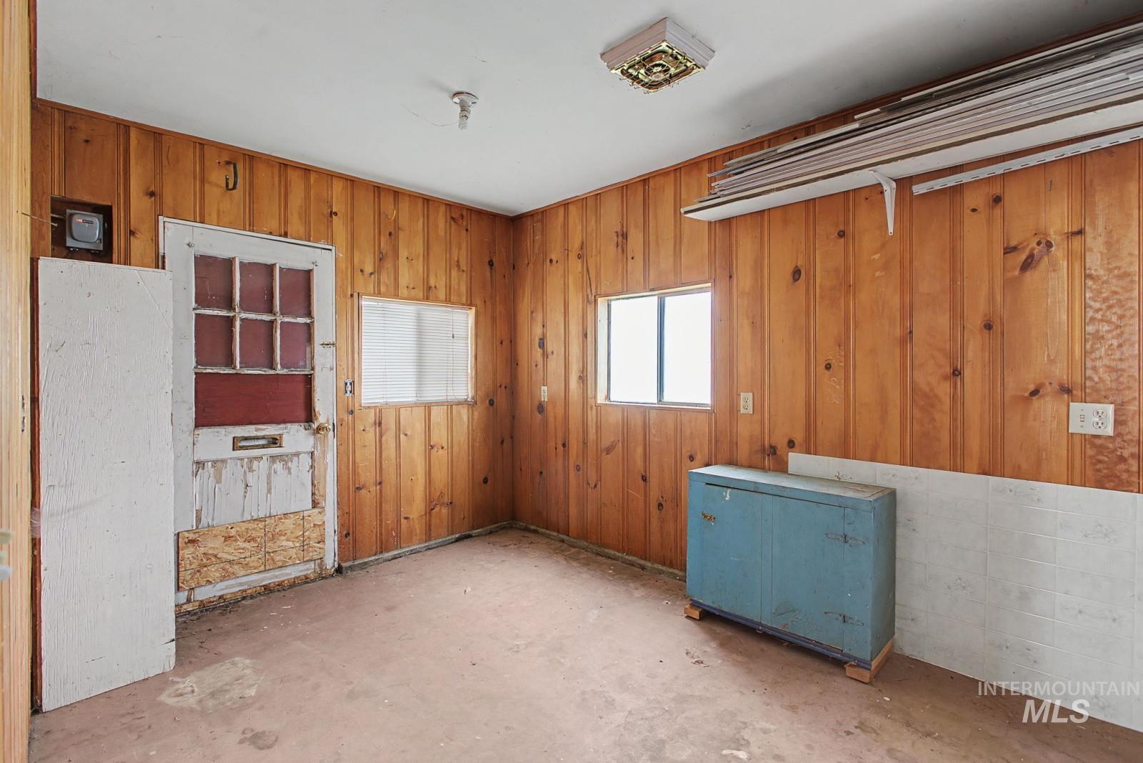 918 Elm Street Clarkston, WA 99403 - Photo 26 of 35 Unfurnished room with wooden walls and unfinished concrete floors