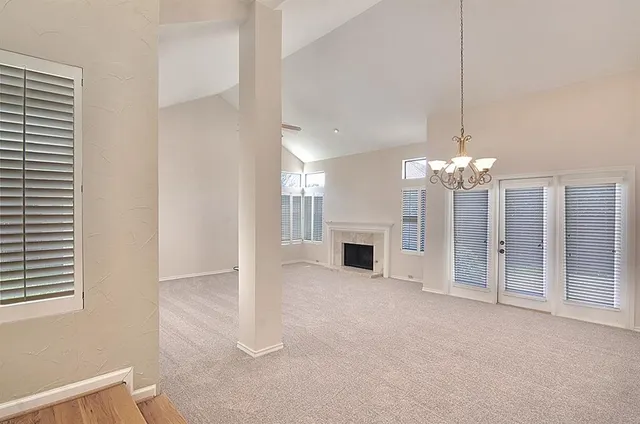 a view of a livingroom with a chandelier fan and fireplace