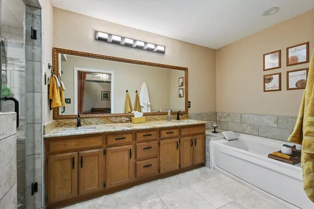 a spacious bathroom with a granite countertop tub sink and mirror