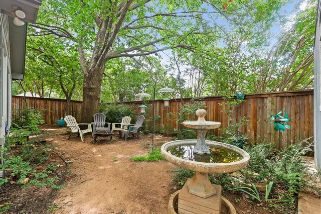 a view of a patio with table and chairs and wooden fence