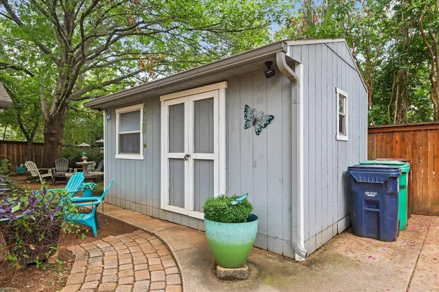 front view of house with table and chairs under an umbrella
