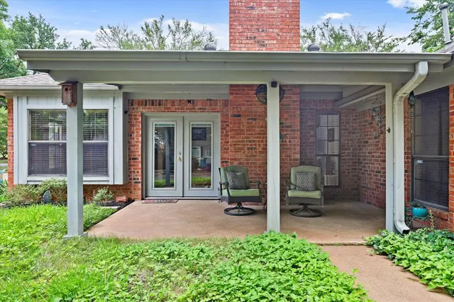 a view of a backyard with plants and large trees