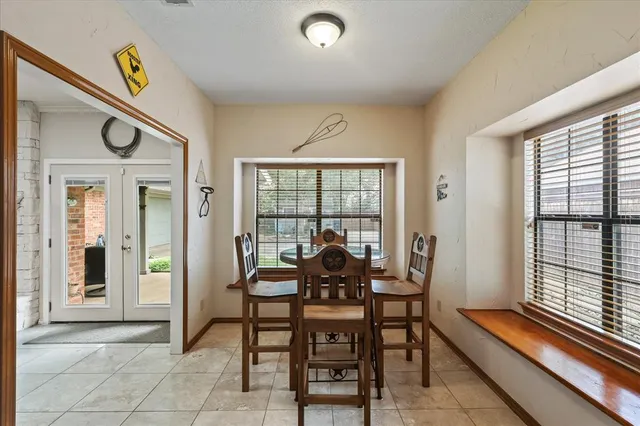 a dining room with furniture and a floor to ceiling window