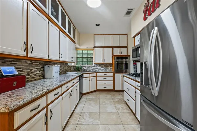 a kitchen with stainless steel appliances granite countertop a refrigerator and a sink